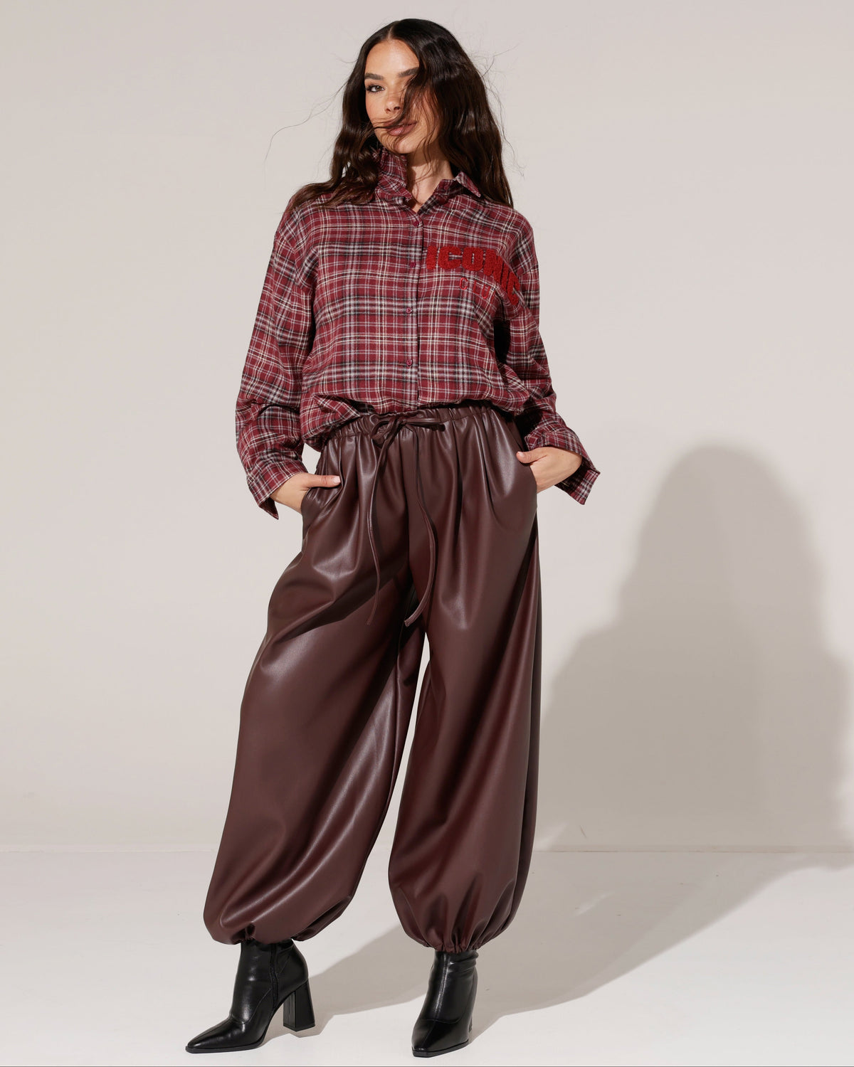 Model in bordeaux geruite blouse en leatherlook ballonbroek uit de nieuwe collectie