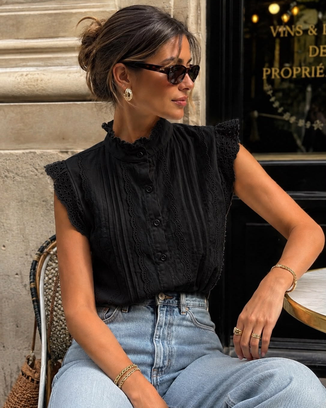 Zwarte mouwloze blouse met kant Nance gedragen met een lichtblauwe jeans