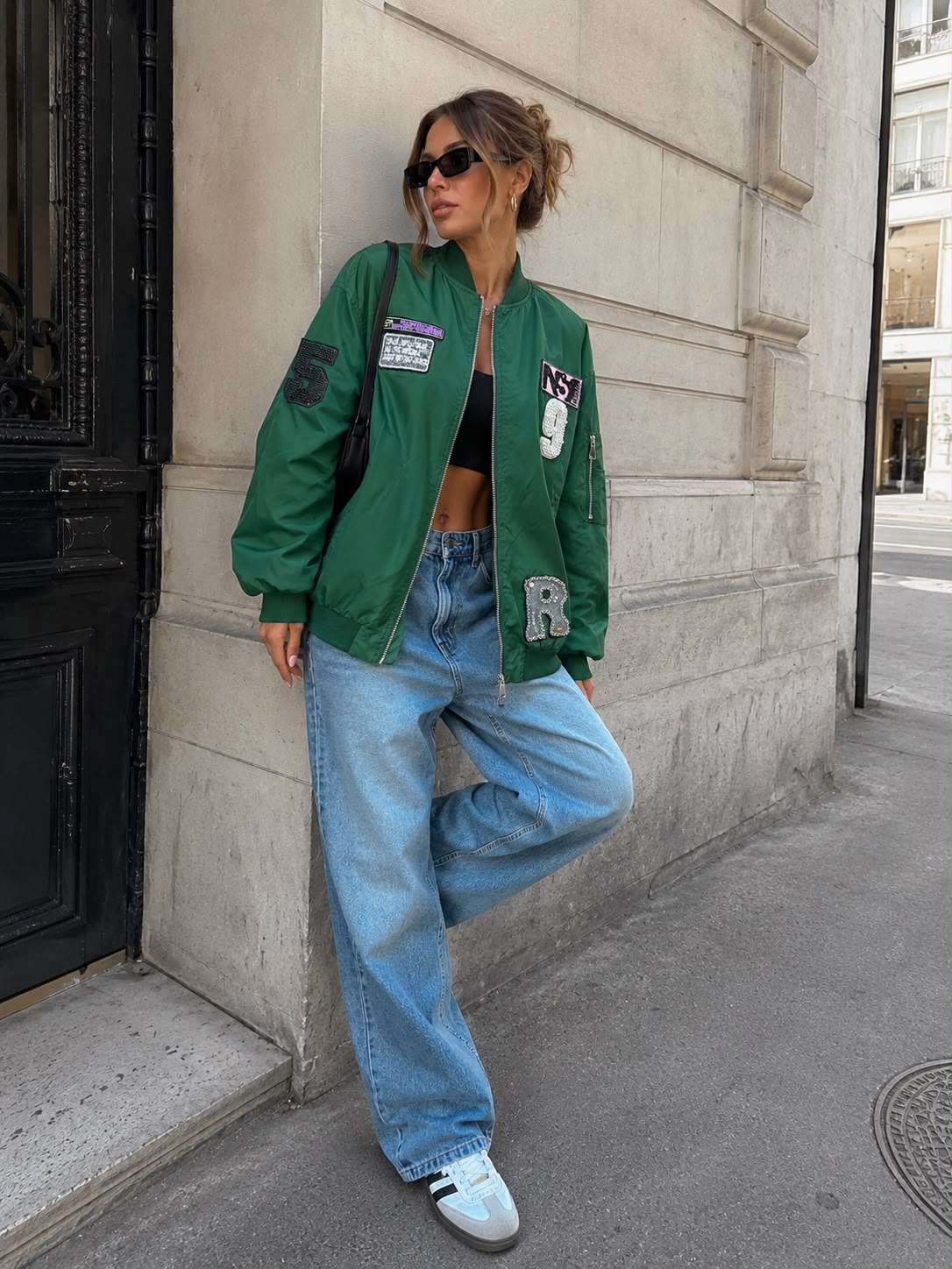Oversized groen bomberjacket Gigi gedragen met blauwe jeans en sneakers