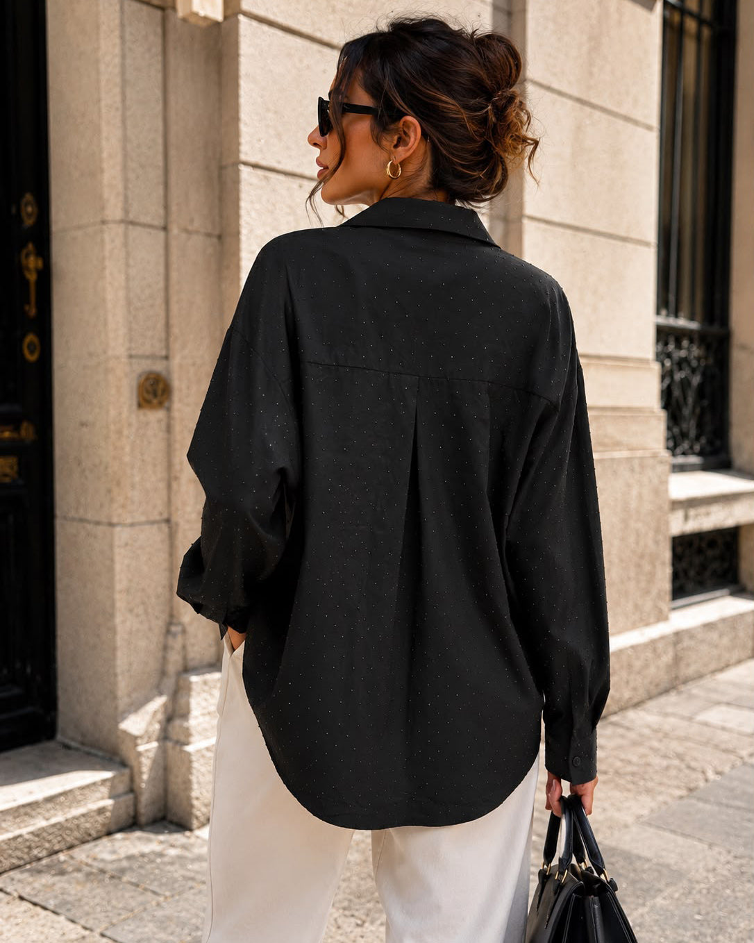 Achterkant van zwarte blouse met strass Vivey met een losse pasvorm en ronde zoom